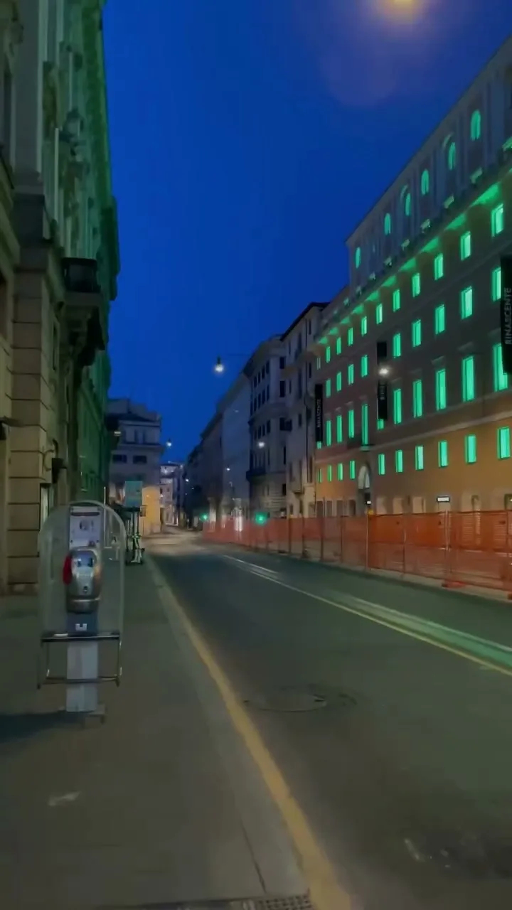 Empty Rome street at dusk with lit facades