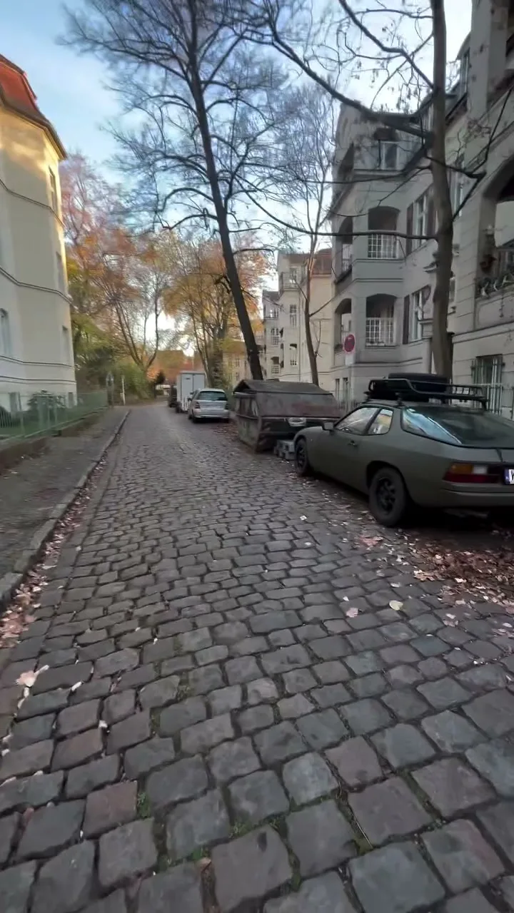 Empty Berlin cobblestone street with a vintage Porsche